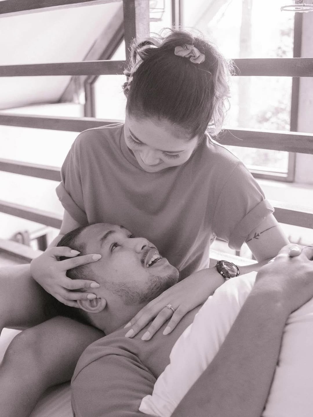 Couple relaxing in the La Cabaña loft, A-frame glass window visible behind them
