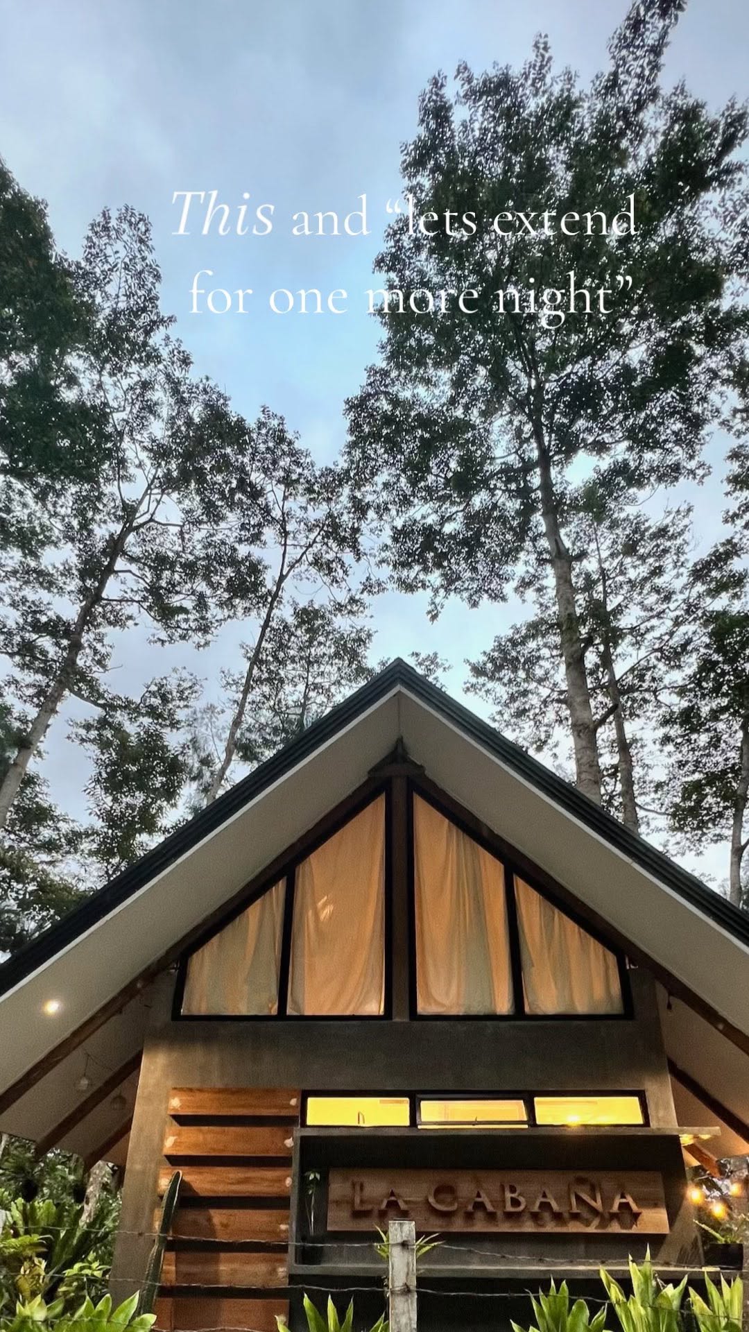 La Cabaña A-frame cabin exterior with wooden sign, framed by tall trees